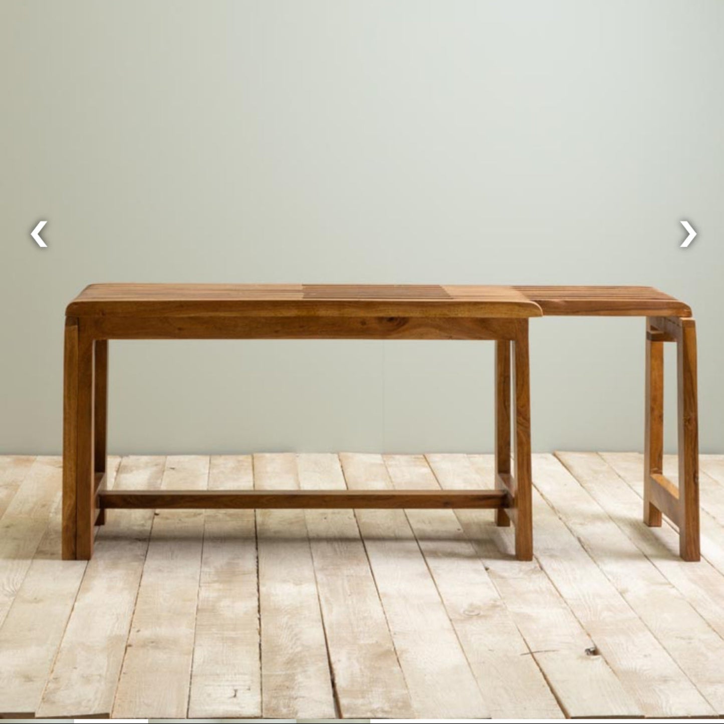 Wooden bench against a plain wall on a wooden floor