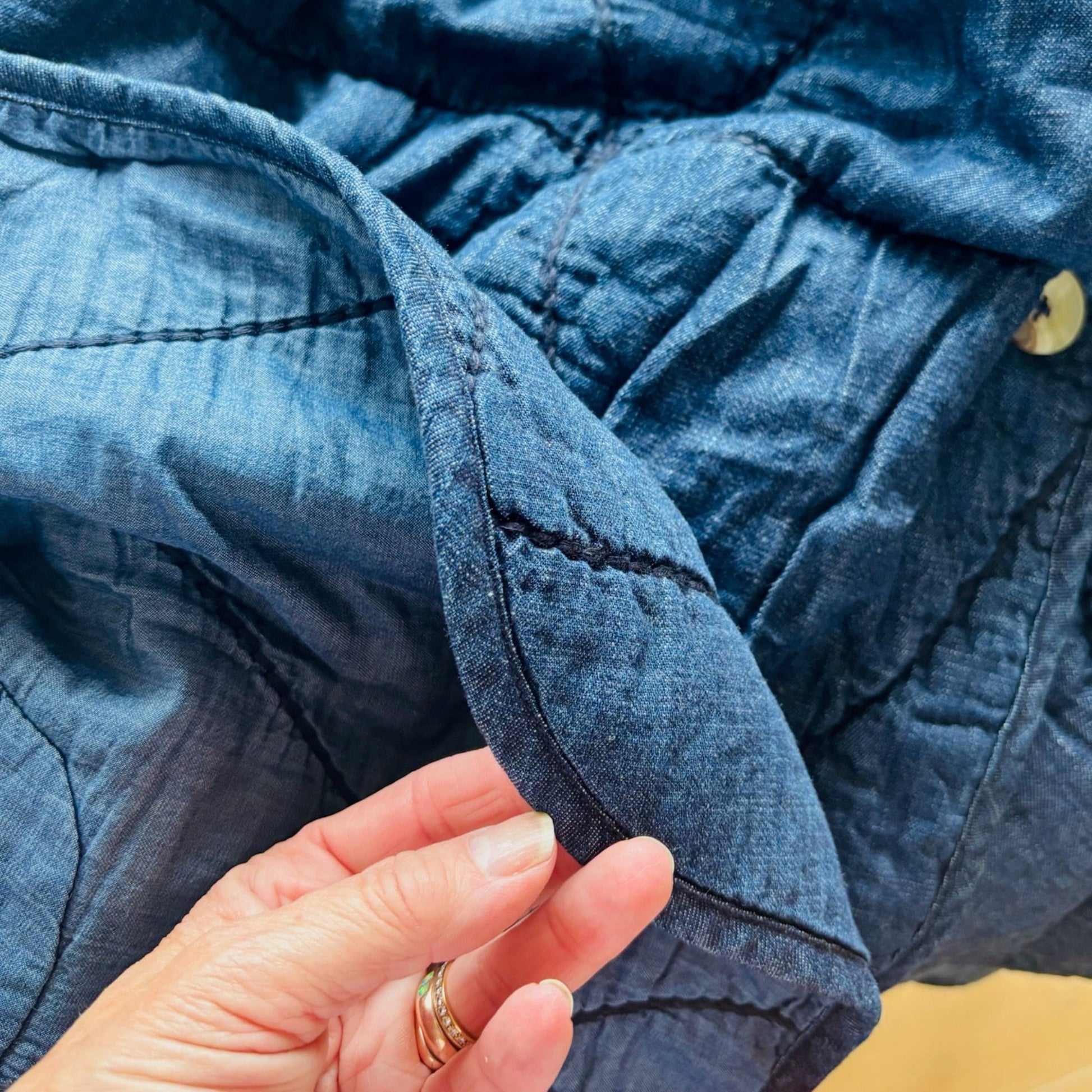 Close-up of blue denim fabric with a hand holding it