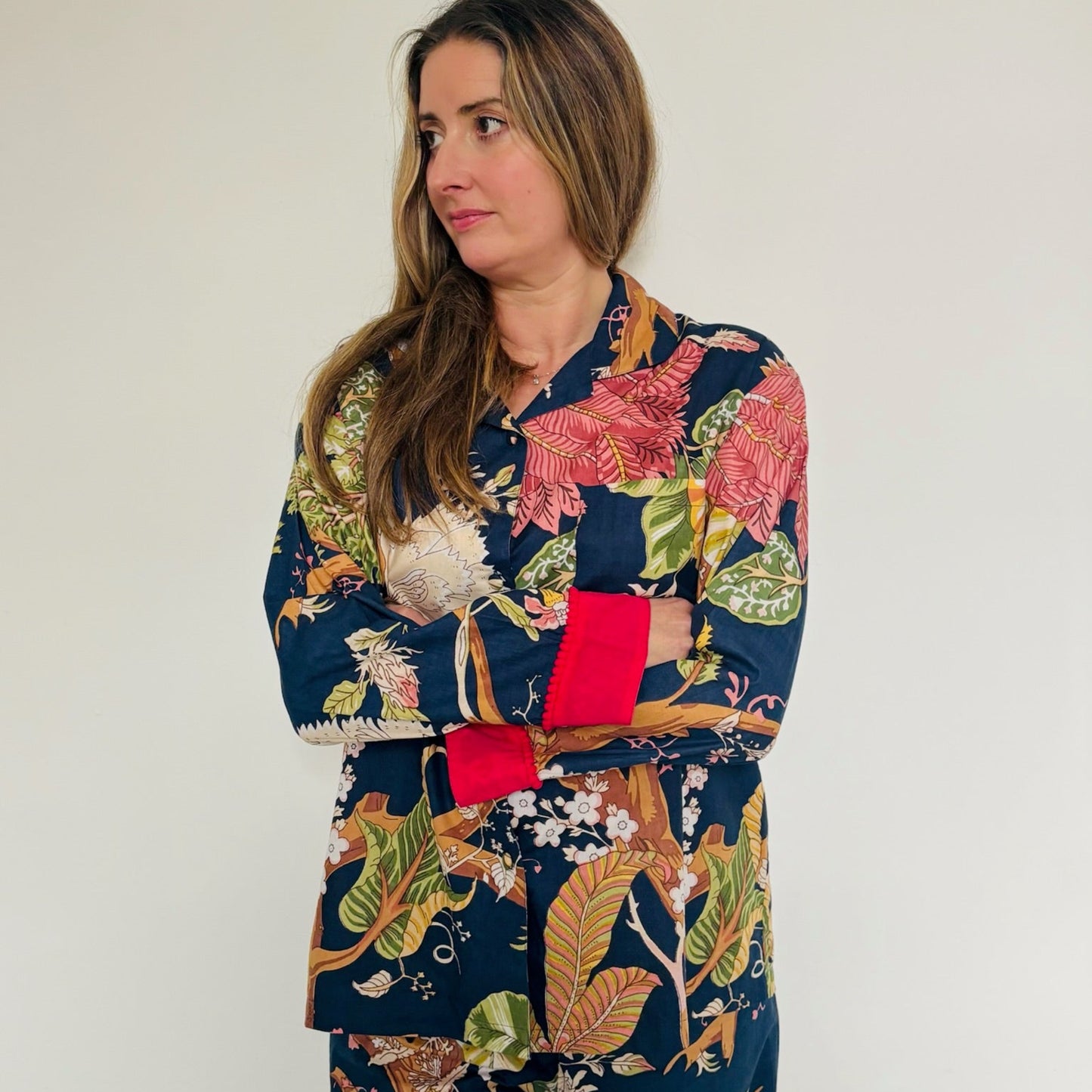 Woman wearing a colorful floral patterned outfit against a plain background