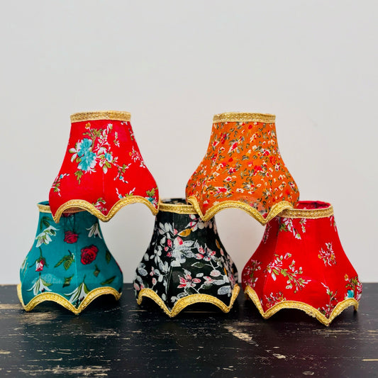 Set of colorful fabric lampshades with floral patterns on a dark surface.