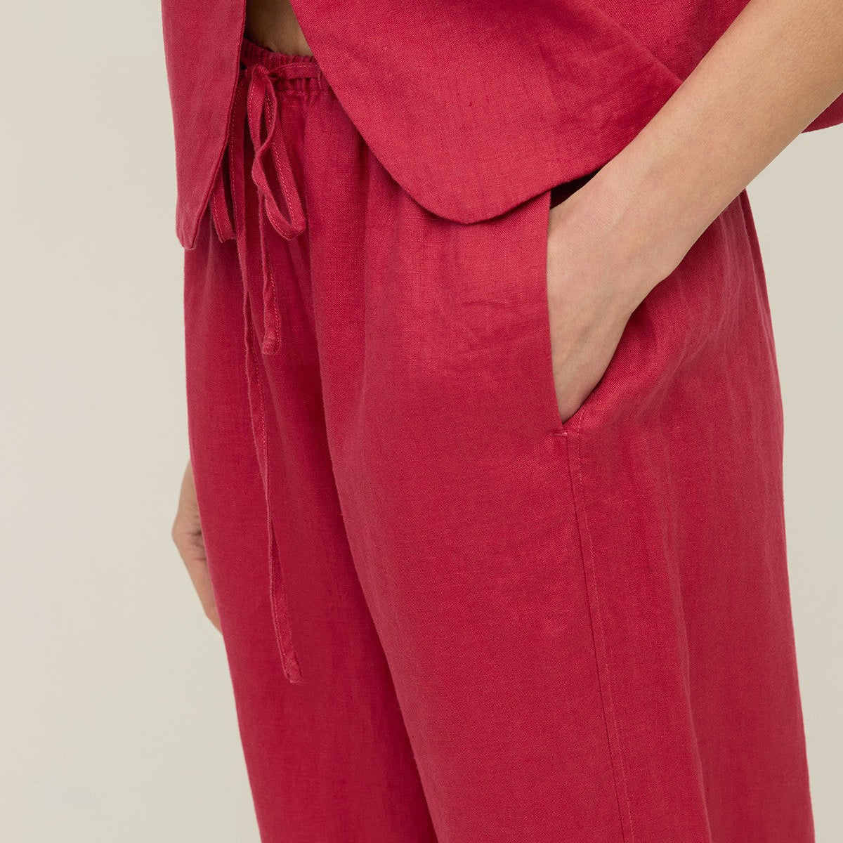 Red outfit with a jacket and pants on a neutral background