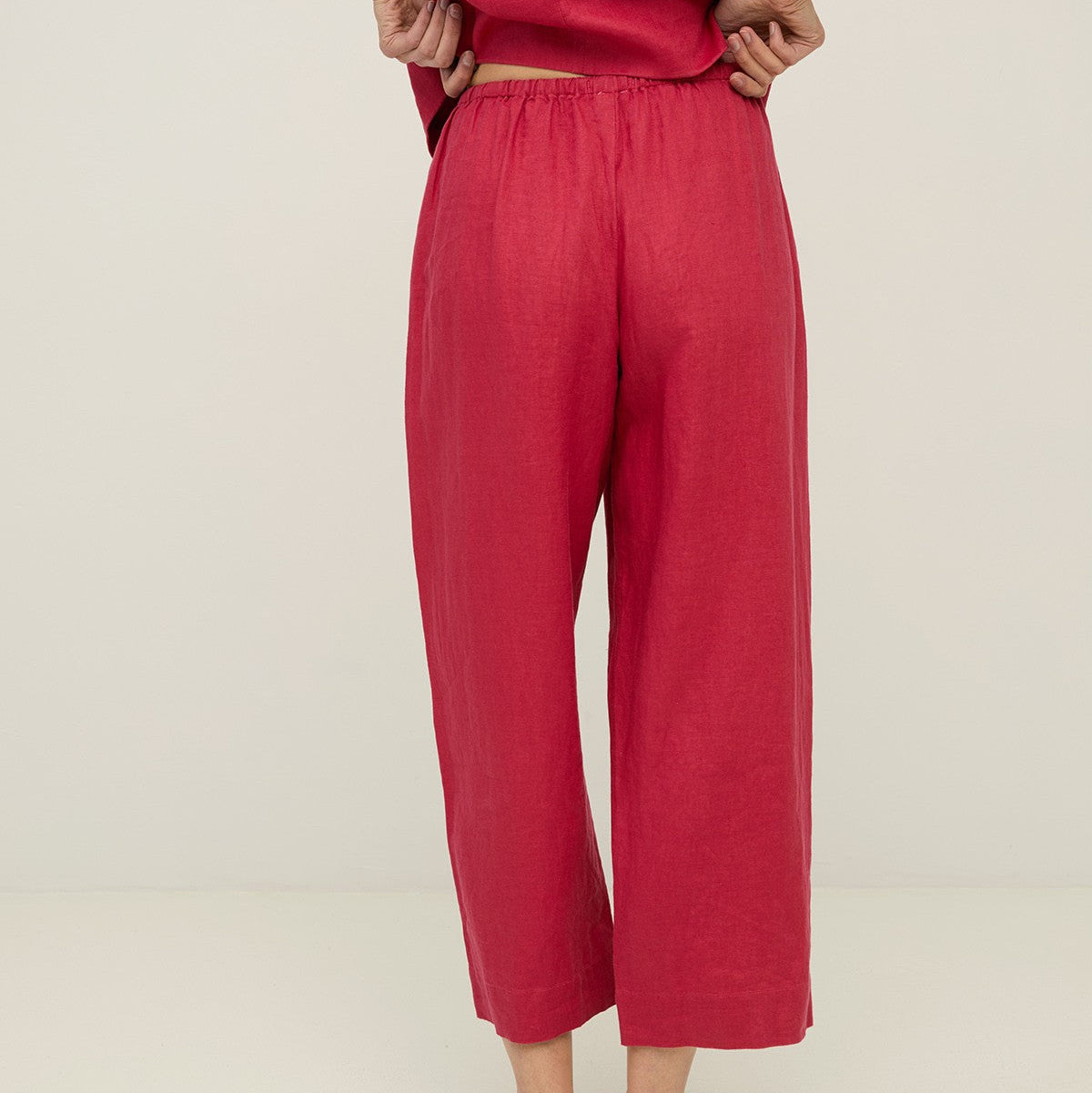 Person wearing red pants and a red top on a plain background