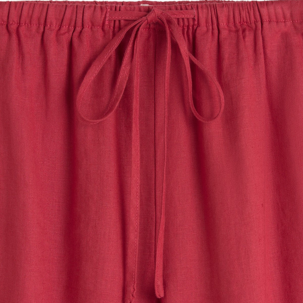 Red pants with a tie detail on a white background