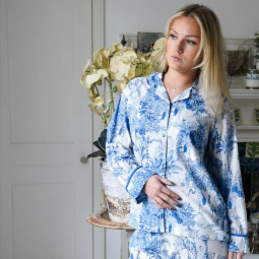 Woman wearing blue and white floral pajamas in a bathroom.