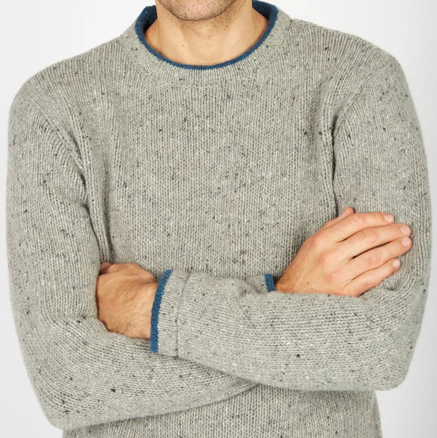 Man wearing a gray sweater with blue trim on a white background