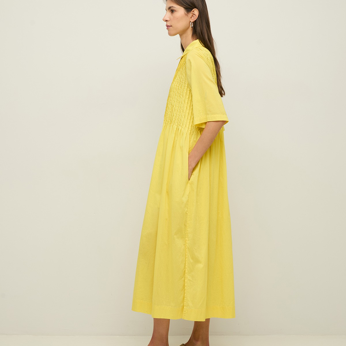 Woman wearing a yellow dress against a white background