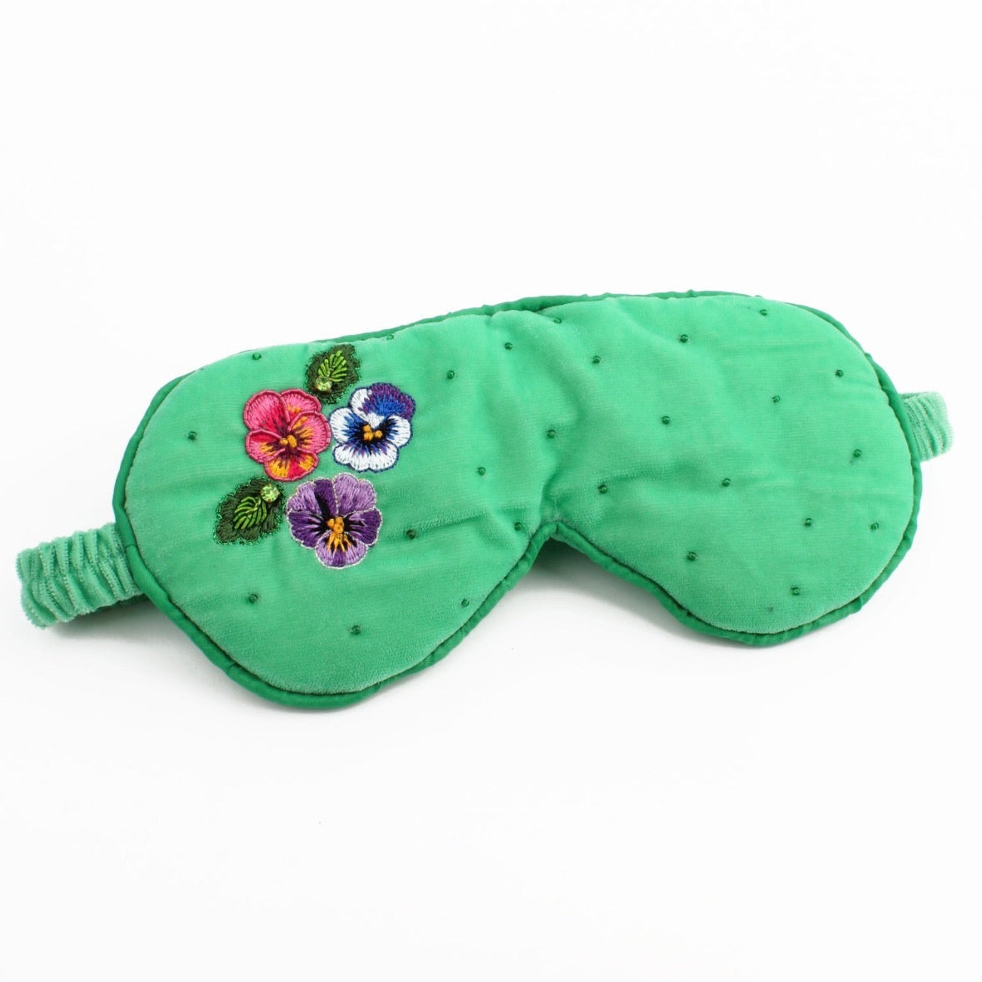 Green eye mask with floral embroidery on a white background