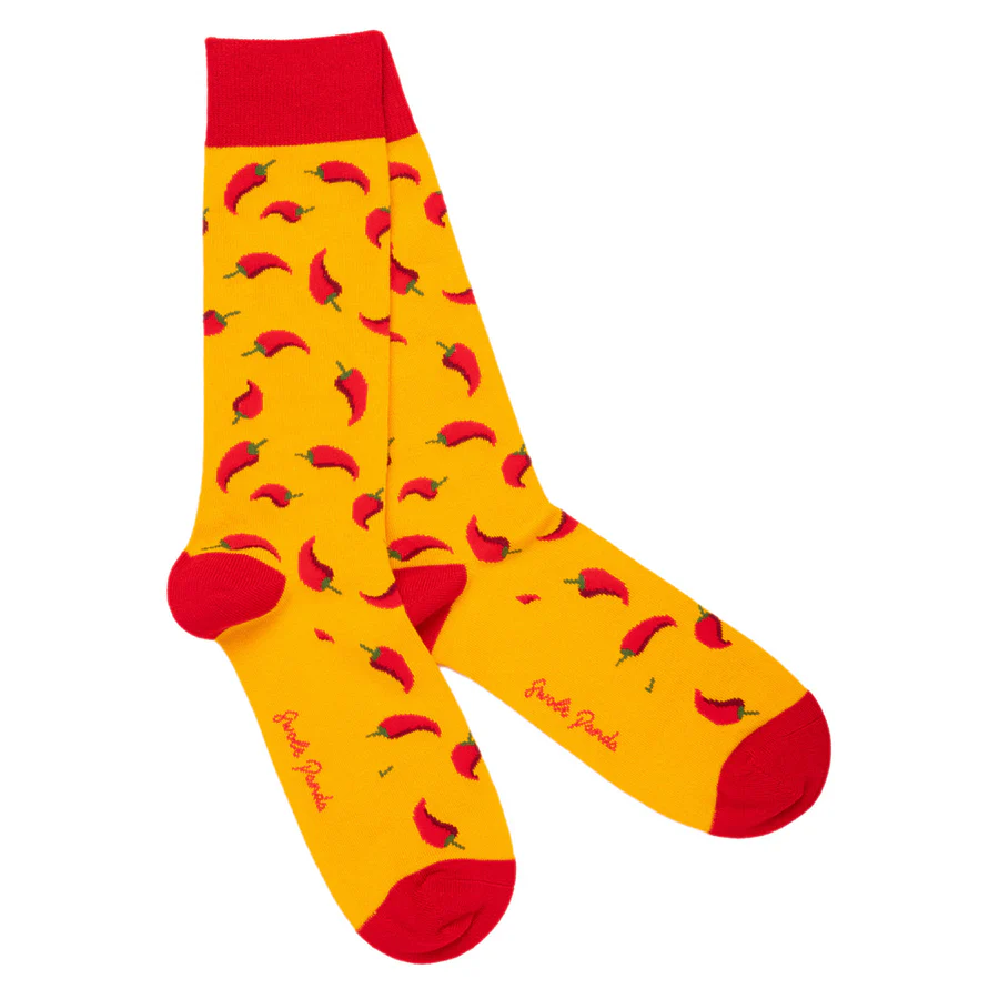 Yellow sock with red chili pepper pattern and red cuff and toes on a white background