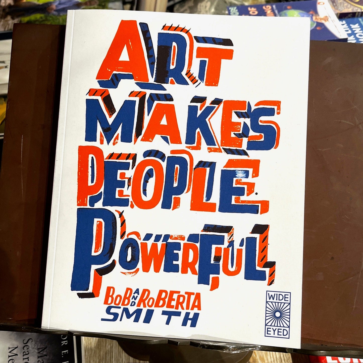 Book cover with colorful text 'Art Makes People Powerful' by Bobbi Roberta Smith on a bookshelf background.