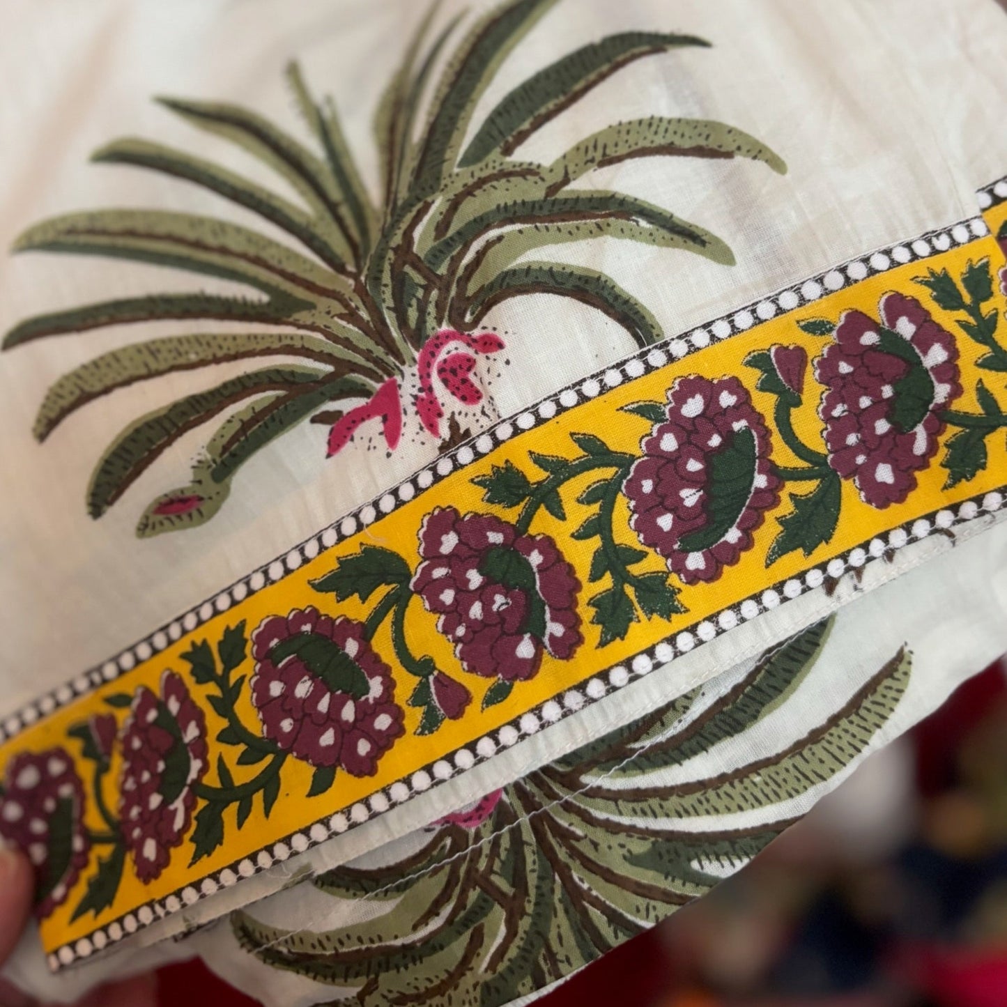 Embroidered fabric with floral patterns and a yellow border