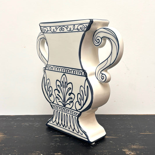 Decorative ceramic vase with blue patterns on a wooden surface and white background