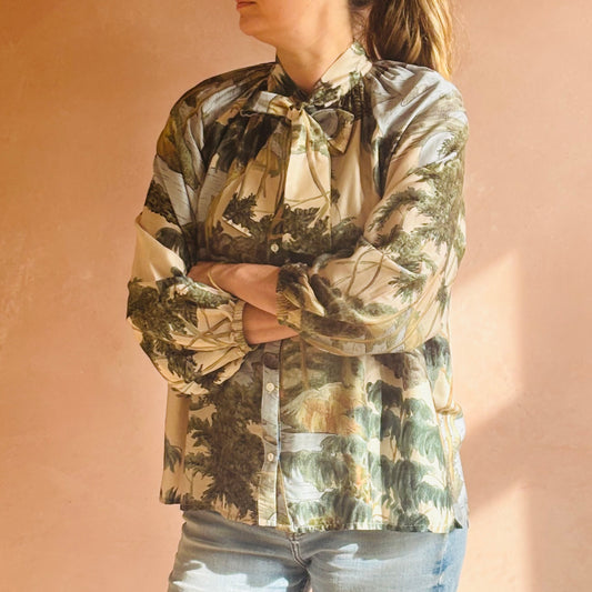Person wearing a camouflage shirt against a beige background